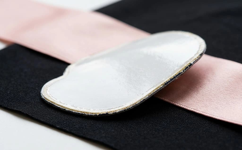 Close-up of costume-safe flexible dance patch backing resting on delicate performance fabric